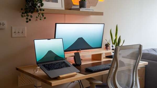 Bright organised desk with a laptop, notebook, and calm workspace setting